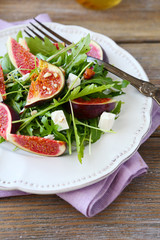 Salad with arugula, figs and cheese on a plate
