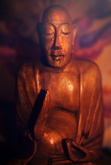 A wooden statue of meditating Buddha