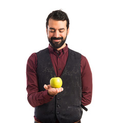 Man wearing waistcoat holding an apple