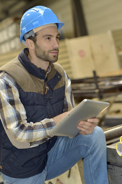 Engineer in metallurgical factory using tablet