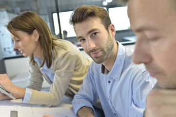 Portrait of architect amongst group in meeting