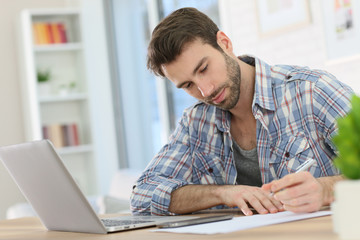 Home-office worker taking notes on paper