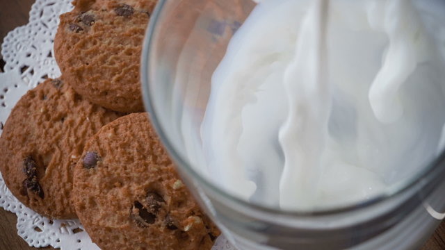 Cookies and glass of milk, on wooden table