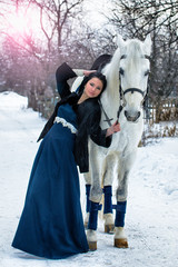 Girl in blue on a White horse in winter