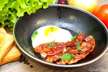 bacon and eggs in a frying pan