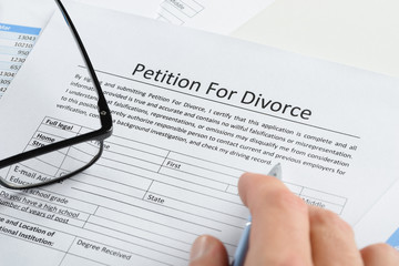 Hand With Pen On Petition For Divorce Paper