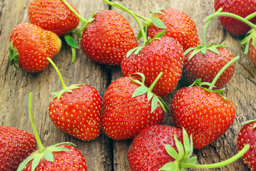 Ripe red strawberries on a wooden background.