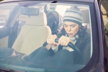 Close-up of a frustrated woman behind the steering wheel