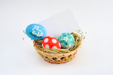 Colorful Easter eggs in basket and blank card