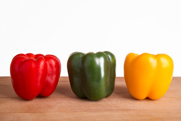 Red, green and yellow pepper on a white background