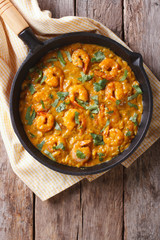 Shrimp in curry sauce in the pan. Vertical top view