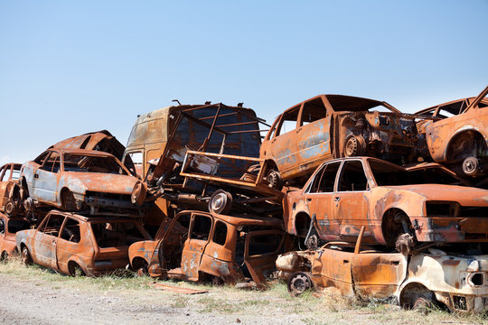 Stack od dameged rusted car scraps on junkyard