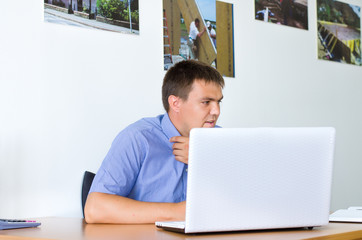 Young man sitting working on a laptop