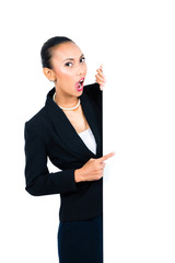 Asian businesswoman showing empty white board