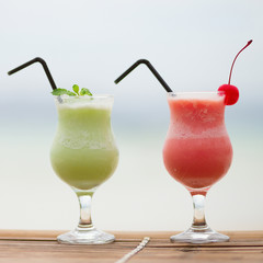 Two fresh fruit juices on a tropical beach