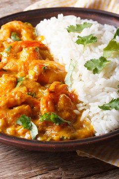 Shrimps in curry sauce with rice and cilantro vertical
