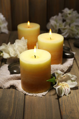 Fototapeta na wymiar Beautiful candles with flowers on wooden background