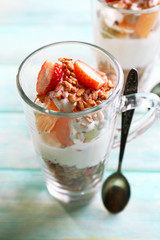 Healthy layered dessert with muesli and strawberries on table