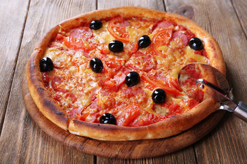 Tasty pizza with black olives and round knife