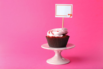 Delicious cupcake with inscription on pink background