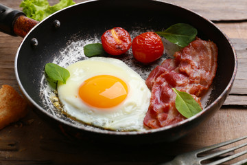 Bacon and eggs on rustic wooden planks background