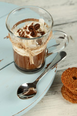 Cup of coffee with cream and cookies on wooden background