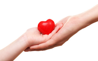 Heart in child and mother hands isolated on white