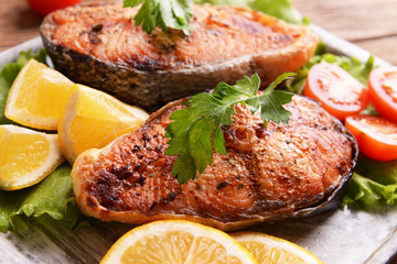 Tasty baked fish on plate on table close-up