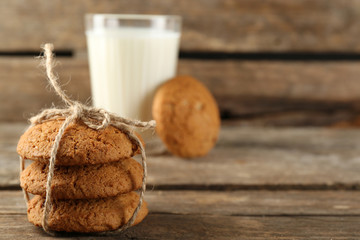 Fototapeta na wymiar Tasty cookies and glass of milk on rustic wooden background