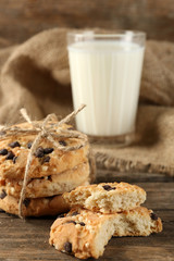 Tasty cookies and glass of milk on rustic wooden background