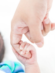 Close-up of baby's hand holding mother's finger