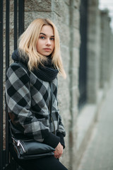 Naklejka na ściany i meble Art portrait of a young blonde woman in a in plaid jacket