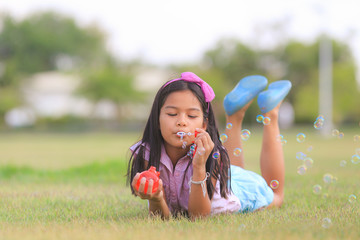 Asian little girl is blowing a soap bubbles