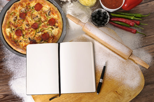 Pizza cooking baking with recipe notebook and ingredients photo