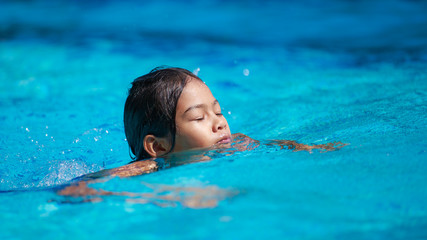 Cute girl with goggles in swimming pool