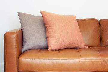 Close up of tan leather sofa with linen cushions