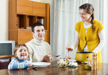  family of three having lunch at home
