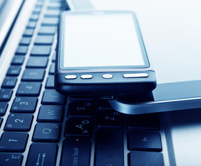 two phones and tablet pc on laptop