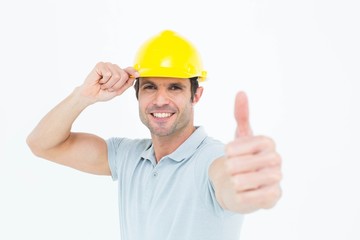 Architect wearing hardhat while showing thumbs up sign