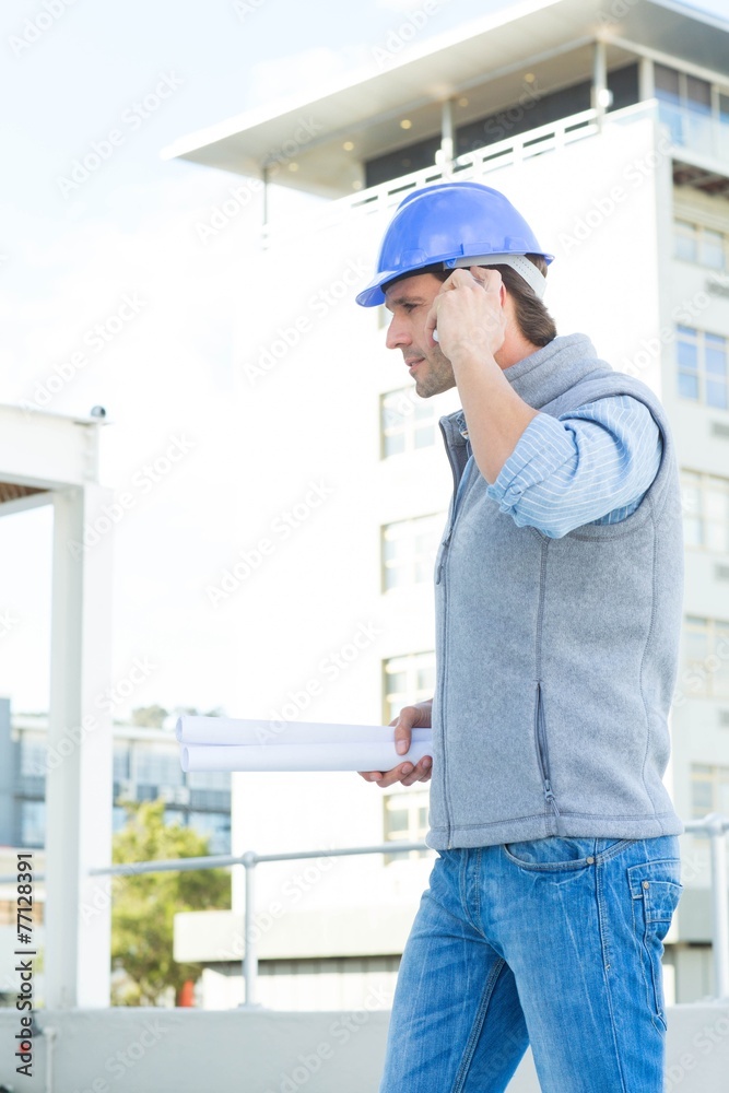 Poster architect using mobile phone outside building