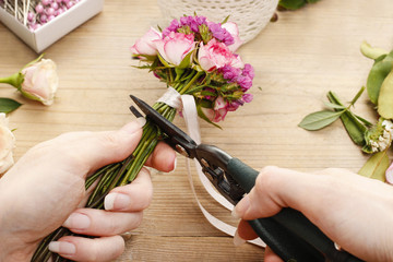 Steps of making wrist corsage. Florist at work.