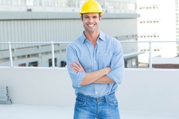 Happy male architect standing arms crossed