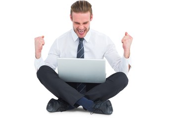 Businessman using laptop and cheering