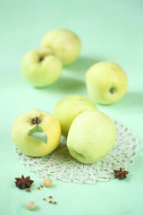 Apples on a lace napkin and light green background.