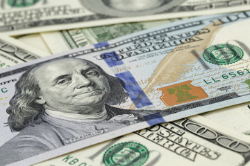 new one hundred dollar note on heap of old notes