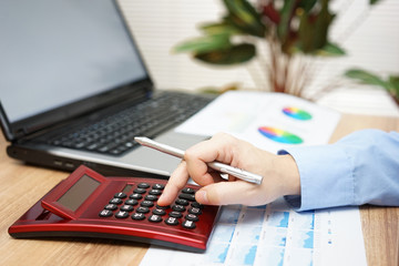 Fototapeta na wymiar businessman analyzing business data with calculator,laptop,repor