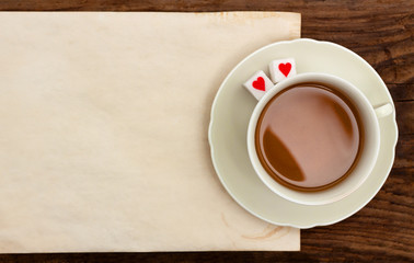 Obraz na płótnie Canvas cup tea note blank paper old table sugar hearts