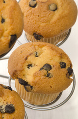 chocolate chip muffin on a metal cake stand