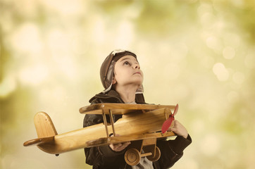 Kleiner Junge mit Holzflugzeug