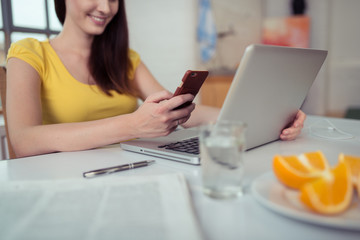 junge frau mit laptop und handy zu hause